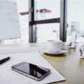 Close up of smart phone and documents on office table --- Image by © John Smith/Corbis